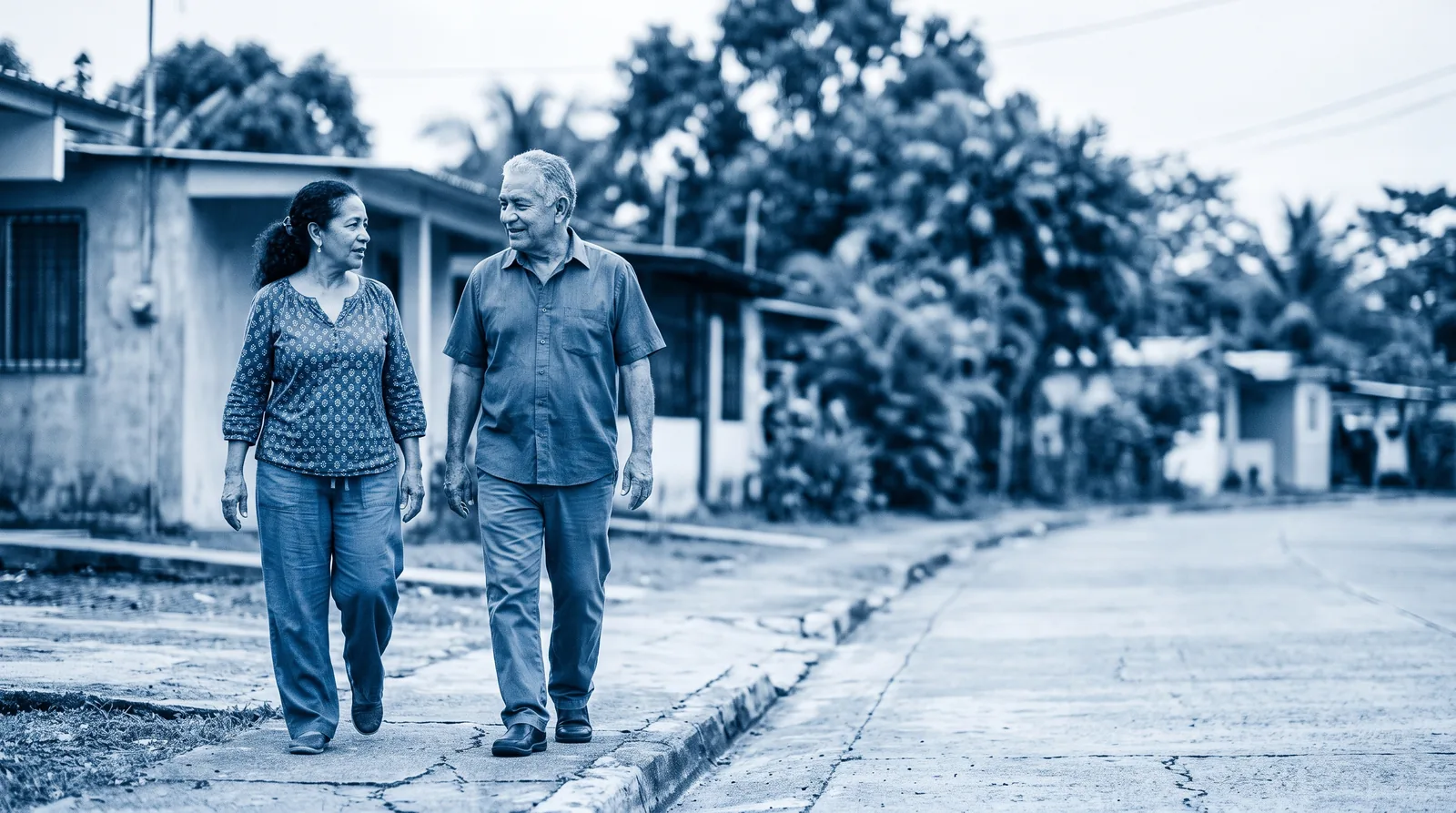 Una pareja de adultos mayores camina conversando por la calle de su barrio.